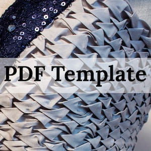 May include: A close-up of a gray fabric with a textured, pleated design. The fabric has a navy blue trim with sequins and rhinestones. The text "PDF Template" is printed in black on a white background.