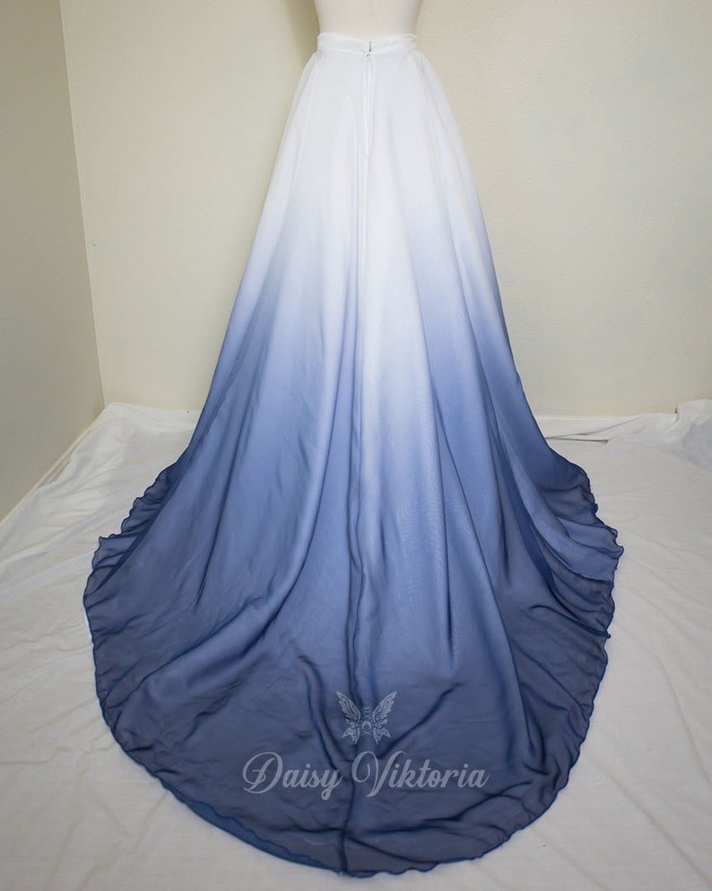 May include: A long white and blue ombre skirt with a zipper in the back. The skirt is made of a soft, flowing fabric and has a ruffled hem.