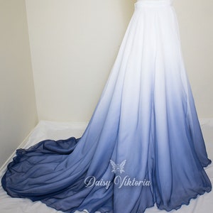 May include: A long white and blue ombre skirt with a ruffled hem. The skirt is made of a sheer fabric and has a high waist.