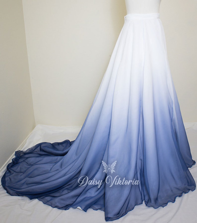 May include: A long white and blue ombre skirt with a ruffled hem. The skirt is made of a sheer fabric and has a high waist.