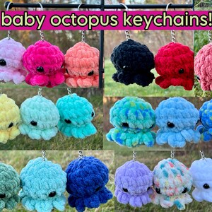 May include: A collection of crocheted baby octopus keychains in various colors, including pink, blue, green, yellow, and white. Each octopus has large, round eyes and eight tentacles.