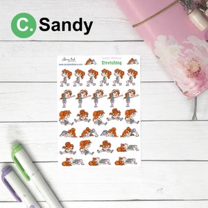 Pu&ograve; includere: Un foglio di adesivi con illustrazioni di una donna dei cartoni animati che esegue esercizi di stretching. Gli adesivi sono etichettati "Sandy's Workout Stretching" e includono il testo "C. Sandy". Sfondo bianco con effetto legno.