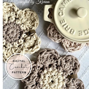 Op de afbeelding: Drie gehaakte bloemachtige onderzetters in beige en bruin. De onderzetters zijn gemaakt van dik garen en hebben een eenvoudig, rustiek ontwerp. De onderzetters zijn perfect om oppervlakken te beschermen tegen hete gerechten.