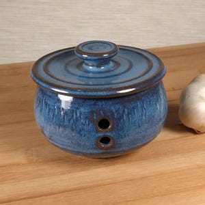 May include: A handmade, wooden cutting board with a natural finish. The board features a live edge, showcasing the wood's unique grain and shape. It is approximately 18 inches long and 12 inches wide.