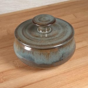 May include: A rustic wooden sign with the text "Welcome to our home" in white lettering. The sign features a distressed finish and a simple, inviting design, perfect for a front porch or entryway.