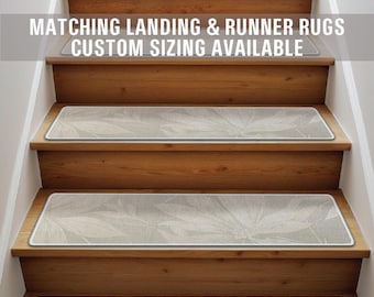 May include: A set of beige stair treads with a subtle leaf pattern. The treads are placed on wooden stairs. The text "Matching Landing & Runner Rugs Custom Sizing Available" is displayed above the stairs.