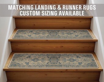 Op de afbeelding: Een set beige en blauwe getrapte treden met een witte rand. De treden zijn op een houten trap. De tekst "Matching Landing & Runner Rugs Custom Sizing Available" staat bovenaan de afbeelding.