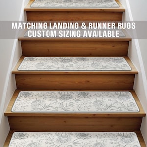 May include: A set of four white stair treads with a gray floral pattern. The treads are on a wooden staircase. The text "Matching Landing & Runner Rugs Custom Sizing Available" is at the top of the image.