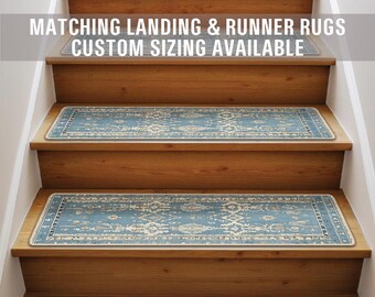 Op de afbeelding: Een set van vier blauwe en crèmekleurige trapmatten met een witte rand. De trapmatten liggen op een houten trap. De tekst "Matching Landing & Runner Rugs Custom Sizing Available" staat bovenaan de afbeelding.