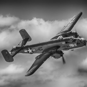 May include: A black and white photo of a vintage military aircraft flying in the clouds. The plane has a star on the side and the text "MB II" on the tail.