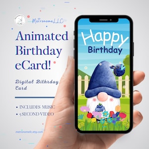 May include: A smartphone displaying an animated birthday eCard featuring a gnome with a blue hat and white beard in a garden. Text on the screen reads Happy Birthday. The background includes a white fence, green grass, and colorful flowers.