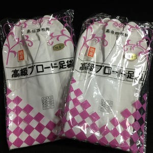 May include: Two pairs of white tabi socks in clear plastic packaging. The socks have a pink and white checkered pattern on the bottom. Japanese text is visible on the packaging, along with a size indicator of 26.0.