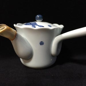 Könnte beinhalten: Set aus drei Keramikbehältern mit Deckeln, verziert mit einem blau-weißen Blumenmuster. Der größte Behälter ist etwa 20 cm hoch. Geeignet für die Küchenaufbewahrung.