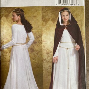 May include: A sewing pattern for a medieval-style gown with a long, flowing skirt and a fitted bodice. The pattern includes a hooded cape with a burgundy lining. The pattern number is B4377 and the size range is 14-16-18-20.