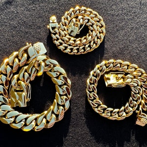 May include: Three gold-colored chain link necklaces of varying lengths. The chains are all made of thick, chunky links.