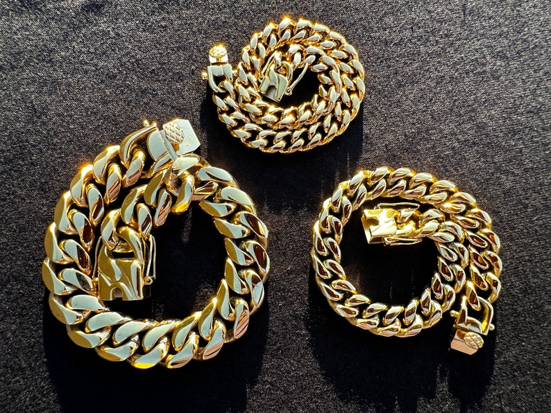 May include: Three gold-colored chain link necklaces of varying lengths. The chains are all made of thick, chunky links.