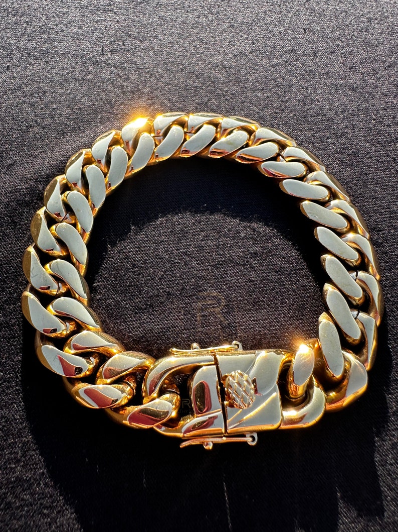 May include: A gold chain bracelet with a large, chunky link design. The bracelet has a secure clasp.