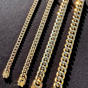 May include: Four gold chains of different lengths and widths. The chains are arranged in a row, with the shortest chain on the left and the longest chain on the right.