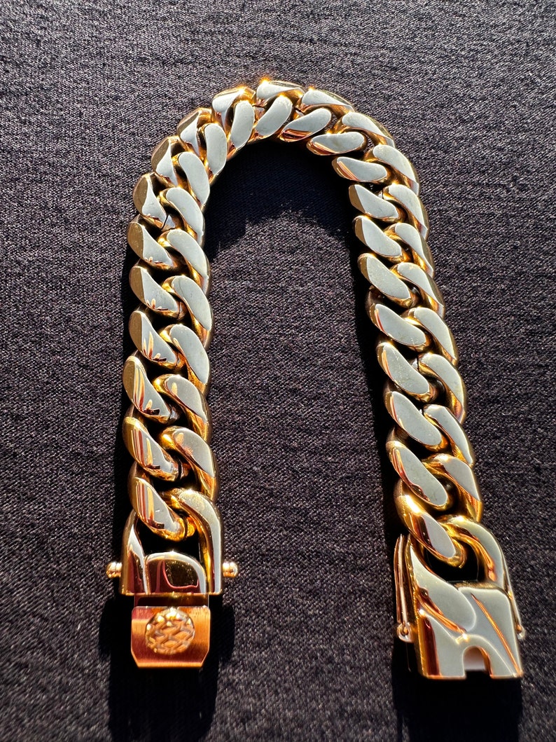 May include: A gold-toned chain bracelet with a curb link design. The bracelet has a clasp closure.