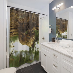 May include: A shower curtain with a close-up image of a brown and tan tree branch with a blurred green background.