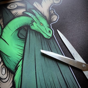 Puede incluir: Una ilustraci&oacute;n de un drag&oacute;n verde sobre un fondo verde oscuro. El drag&oacute;n est&aacute; enroscado y tiene un ojo amarillo. Un par de tijeras plateadas son parcialmente visibles en la esquina inferior derecha de la imagen.