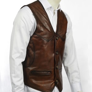 Elevate your style with this handcrafted Leather Vest Men in rich brown sheepskin. Perfect for cowboy, biker, motorcycle, or western fashion enthusiasts, this waistcoat blends timeless appeal with superior craftsmanship. Made from 100% genuine lamb leather, it offers a luxuriously soft feel and durable wear that ages beautifully over time.