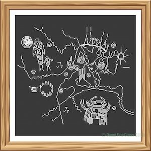 May include: A framed cross-stitch depicting a white line art design on a dark gray background. The artwork features stylized figures, symbols, and a landscape, reminiscent of ancient petroglyphs. The frame is a warm, natural wood tone.