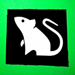 Könnte beinhalten: Ein schwarz-weißes Patch mit einer weißen Silhouette einer Maus auf schwarzem Hintergrund.