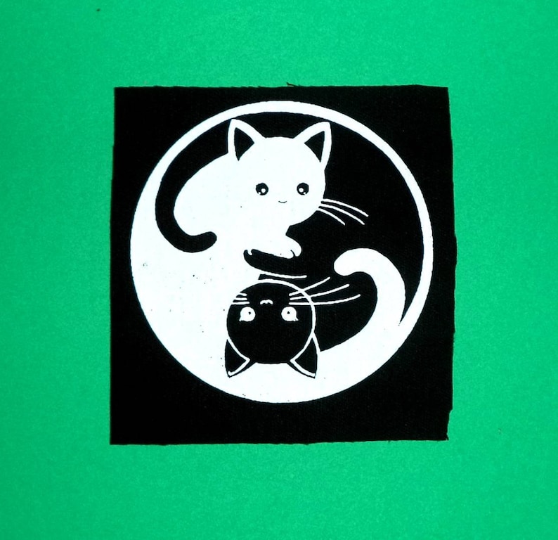 Puede incluir: S&iacute;mbolo yin yang en blanco y negro con dos gatos, uno blanco y otro negro, que se miran.