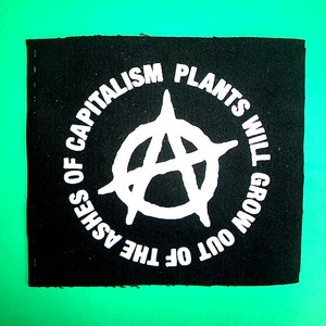Könnte beinhalten: Schwarzer Stoff-Patch mit weißem Text und einem Anarchiesymbol. Der Text lautet "Pflanzen werden aus der Asche des Kapitalismus wachsen."