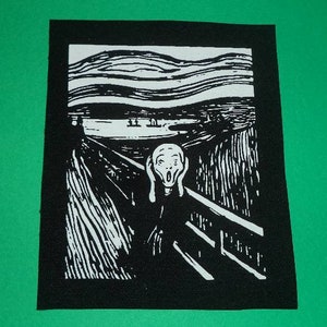 Könnte beinhalten: Schwarz-weiß gestickter Patch von Edvard Munchs Gemälde Der Schrei. Der Patch zeigt eine Figur mit weißem Gesicht und Händen, die sich die Ohren zuhalten, und schreit vor einem schwarz-weißen Hintergrund.