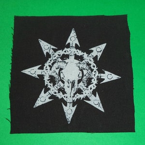 Könnte beinhalten: Ein schwarzer Patch mit einem weißen, achtzackigen Sternmuster. Der Stern hat einen Schädel in der Mitte, umgeben von einem Kranz.