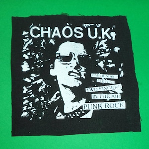Könnte beinhalten: Schwarz-weißes Punkrock-Band-Patch mit dem Text "Chaos U.K." und "One Hundred Percent Two Fingers In The Air Punk Rock".