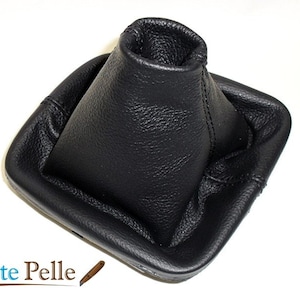 May include: Black leather gear shift boot with a square base and a tall, cone-shaped top.