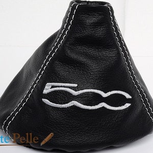 May include: Black leather gear shift knob with white stitching and a white embroidered "500" logo.