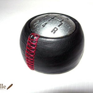 Può includere: Pomello del cambio in pelle nera con cuciture rosse e una parte superiore argentata con i numeri 1, 2, 4, 5 e R.