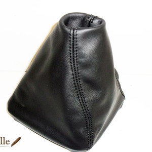 Könnte beinhalten: Schwarzer Lederschalthebelmanschette mit einer Naht.