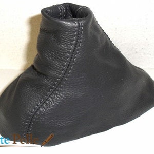 May include: Black leather gear shift boot with white stitching.