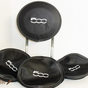 May include: Four black leather headrest covers with white stitching and the word "500" embroidered in white.