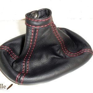 May include: Black leather gear shift boot with red stitching.