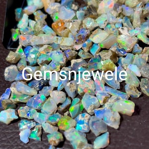 Peut inclure: Un tas de petites pierres précieuses d'opale irisées dans différentes nuances de bleu, vert et blanc. Les pierres précieuses sont brutes et ont un aspect naturel et non poli.