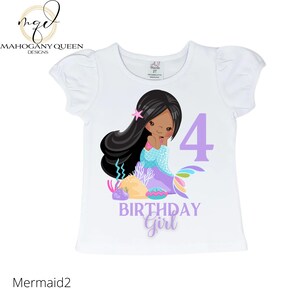 May include: White t-shirt with a purple number 4, the words "Birthday Girl" and a cartoon mermaid with brown hair and a purple tail.