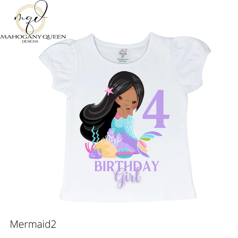 May include: White t-shirt with a purple number 4, the words "Birthday Girl" and a cartoon mermaid with brown hair and a purple tail.