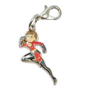 May include: A silver-toned charm featuring a running superheroine in a red and black suit with a yellow belt. The charm has a lobster clasp for easy attachment to a bracelet or necklace. The superheroine has brown hair and a determined expression.