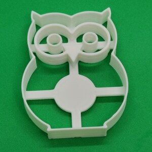 Pu&ograve; includere: Tagliapasta a forma di gufo in plastica bianca. Il tagliapasta ha un design dettagliato con dettagli degli occhi e delle piume. Il tagliapasta &egrave; su una superficie verde. Il tagliapasta &egrave; in plastica ed &egrave; probabilmente per la cottura.