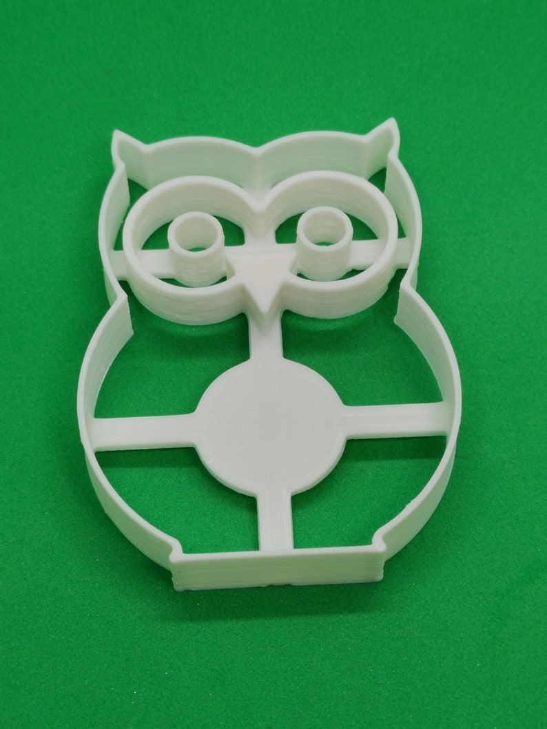Pu&ograve; includere: Tagliapasta a forma di gufo in plastica bianca. Il tagliapasta ha un design dettagliato con dettagli degli occhi e delle piume. Il tagliapasta &egrave; su una superficie verde. Il tagliapasta &egrave; in plastica ed &egrave; probabilmente per la cottura.