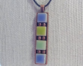 May include: A copper pendant necklace with a vertical mosaic of blue, green, and yellow ceramic tiles. The tiles are separated by copper beads.