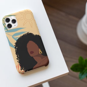 May include: A phone case with a colorful illustration of a woman with curly hair, a sun, and tropical leaves. The background is a light yellow color.