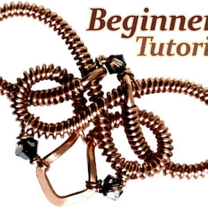 Op de afbeelding: Een sieraad van koperdraad in de vorm van een vlinder met drie zwarte kristallen. Het stuk is getiteld "Beginner+ Tutorial".