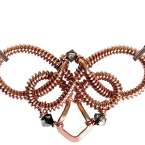 Op de afbeelding: Een koperen draadketting met een geknoopt ontwerp en zwarte kristallen accenten. De ketting is gemaakt van meerdere lussen draad die met elkaar zijn verweven om een uniek en ingewikkeld ontwerp te cre&euml;ren.